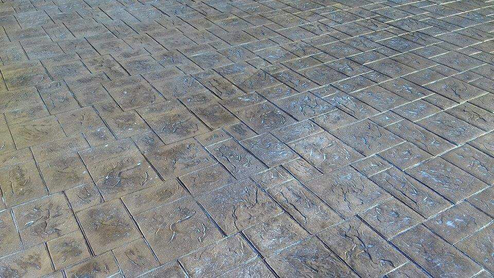 Hormigón impreso gris con molde de adoquín circular para entrada de chalet